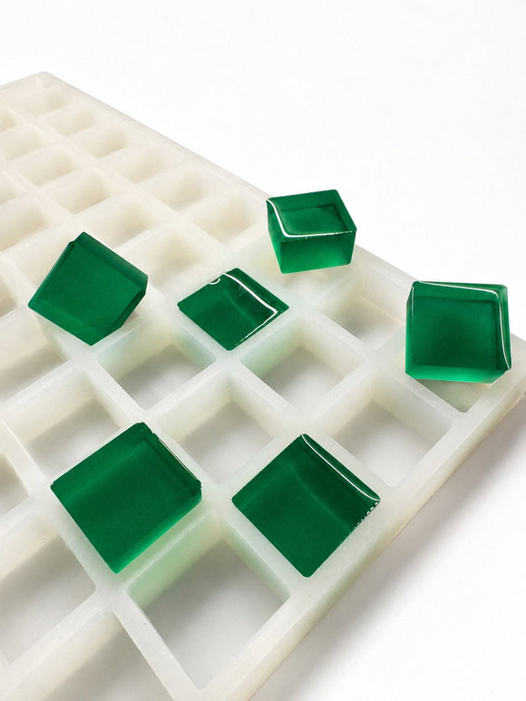 Molde para gomitas cuadradas de 6 mL, 165 cavidades — vista lateral en ángulo; gomitas cuadradas translúcidas verde esmeralda; fondo blanco